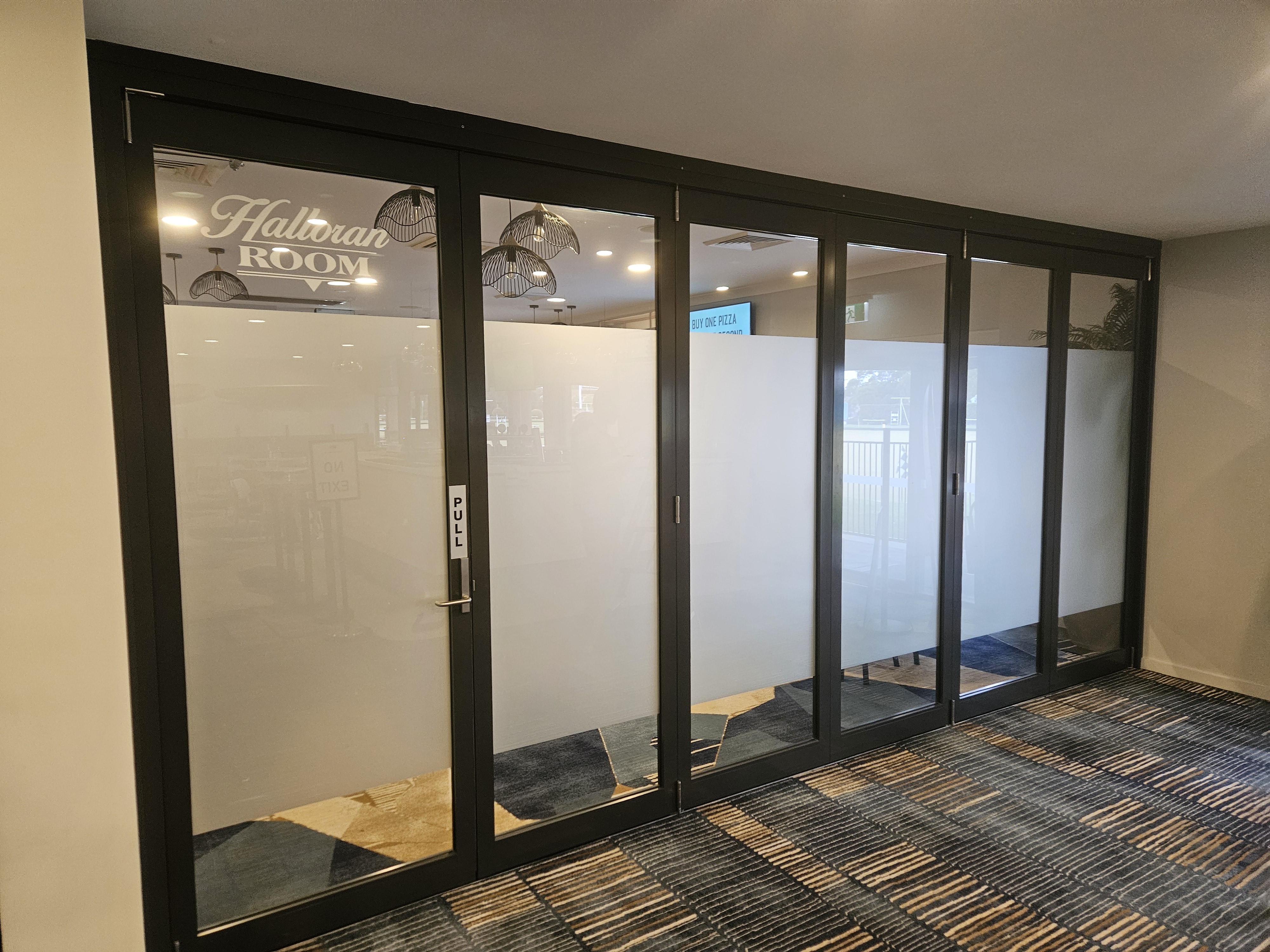 Frosted glass doors and partition glazing inside a Shoalhaven club fitted by All Hours Glass