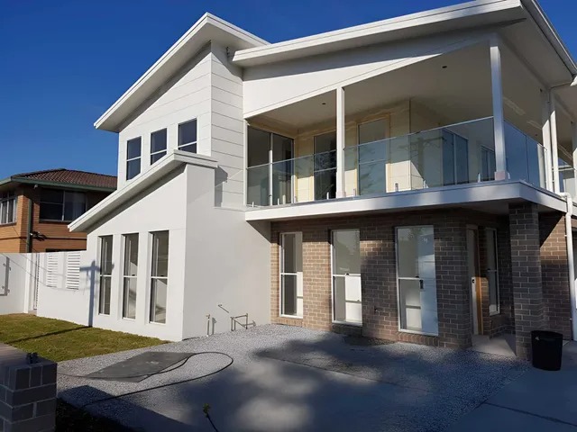 Glass balustrade panels along an upper-storey balcony on a modern home
