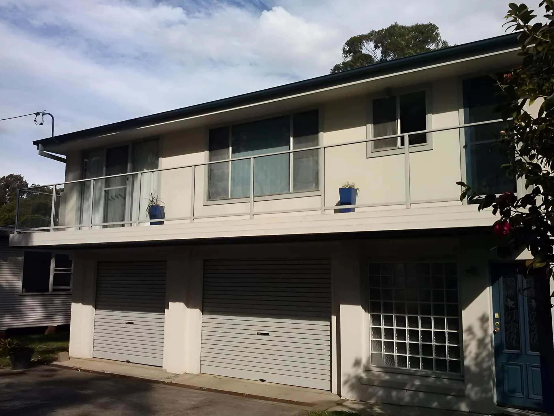 Glass balcony balustrade and window glazing across a two-storey Shoalhaven home