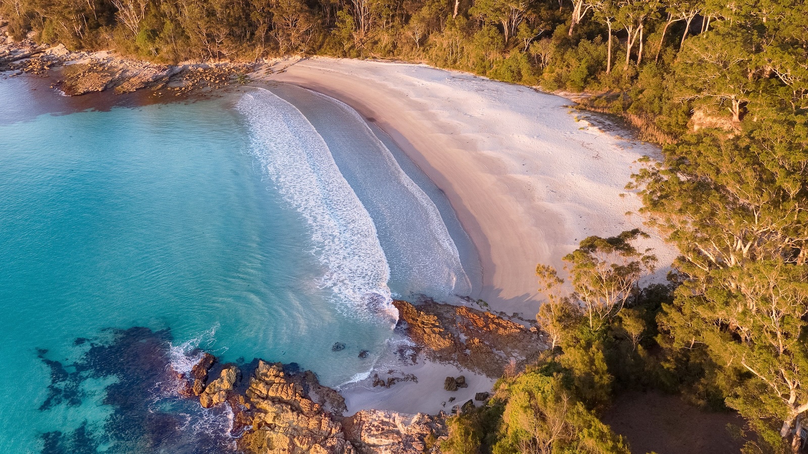 Aerial view of a white sand beach and turquoise water at Vincentia, Jervis Bay