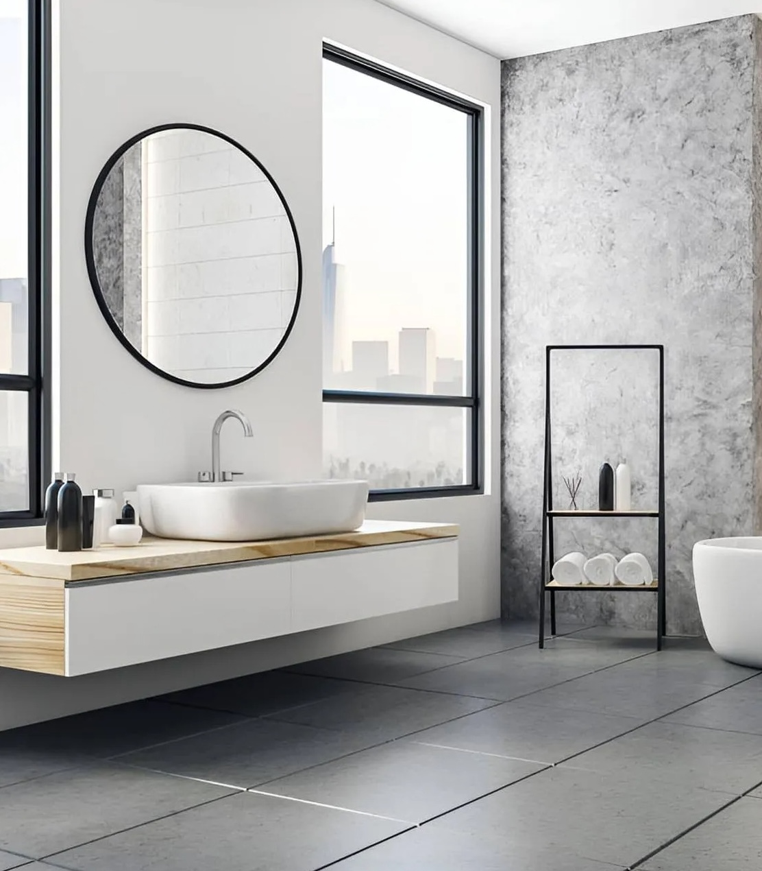 Round black-framed mirror above a floating vanity in a modern bathroom fitted by All Hours Glass