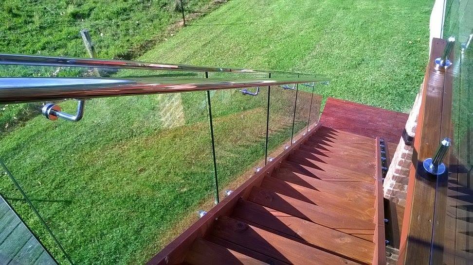 Glass balustrade with stainless handrail along outdoor timber deck stairs