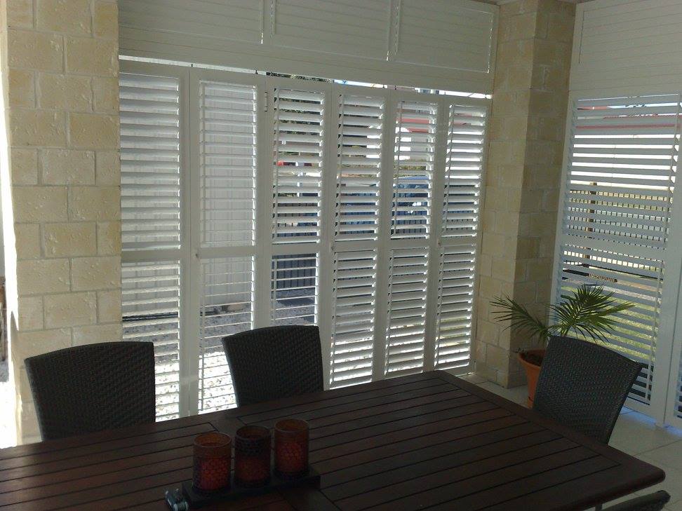 White plantation shutters over sliding glass doors installed by All Hours Glass in a Shoalhaven home