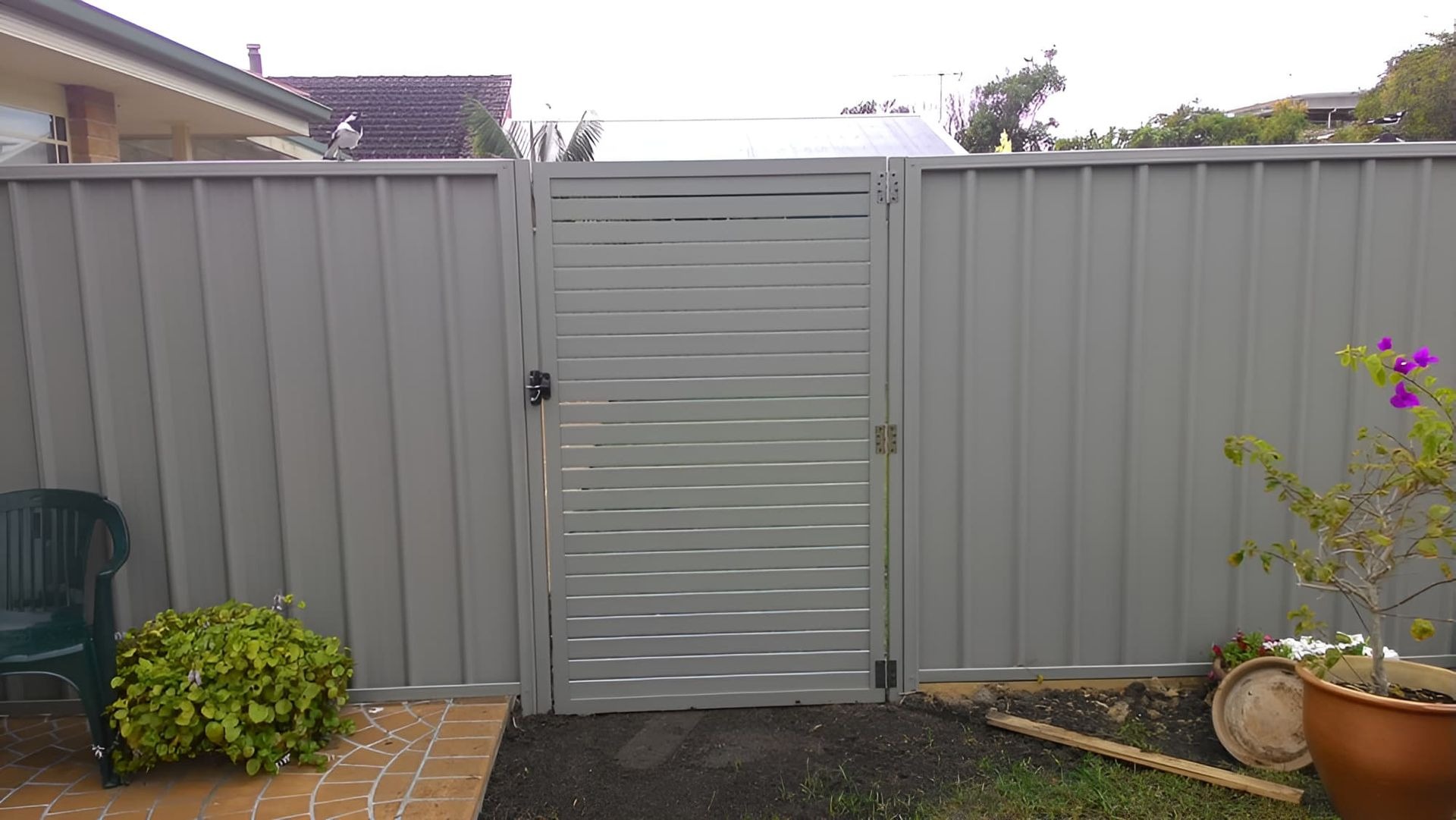 Custom aluminium slat gate fitted to a Shoalhaven backyard fence line